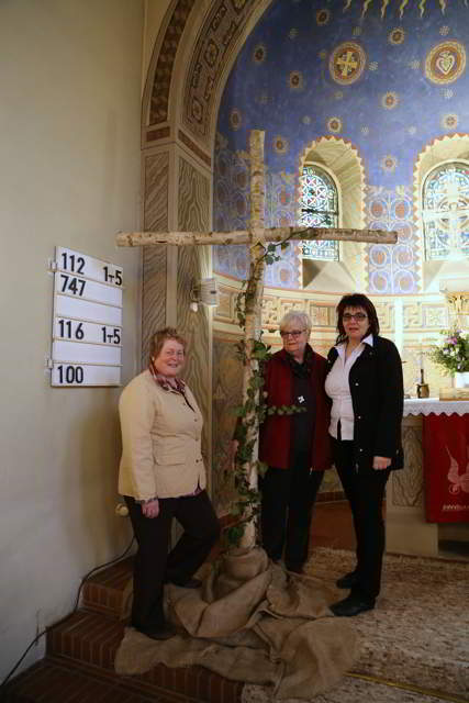 Drei Kirchenvorsteherinnen beschaffen ein Birkenkreuz